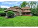 Expansive backyard with lush green lawn, mature trees, and a covered porch for outdoor enjoyment at 11469 Woodview Ct, Fishers, IN 46038