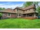 Expansive backyard featuring a brick house with a wooden deck and a well-maintained lawn at 11469 Woodview Ct, Fishers, IN 46038