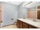 A blue bathroom with a double sink vanity, tile shower, and traditional fixtures at 11469 Woodview Ct, Fishers, IN 46038
