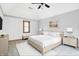 This is a comfortable bedroom with neutral colors, a ceiling fan, and a cozy seating bench at 11469 Woodview Ct, Fishers, IN 46038