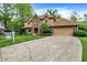 View of the home's entrance, driveway and attached garage with a lawn and light foliage around the building at 11469 Woodview Ct, Fishers, IN 46038