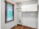 Functional laundry room with ample storage, window and hardwood flooring at 11469 Woodview Ct, Fishers, IN 46038