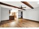 This living room features a hardwood floor, exposed beams, and an open view to the kitchen at 11469 Woodview Ct, Fishers, IN 46038