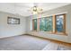 Spacious room with large windows, carpet, and kitchenette area, perfect for entertaining at 11469 Woodview Ct, Fishers, IN 46038