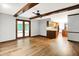 Living room featuring hardwood floors, neutral walls, exposed beams, and a view to the kitchen at 11469 Woodview Ct, Fishers, IN 46038