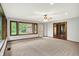 Bright living room featuring plush carpet, a ceiling fan, and large windows offering a serene view at 11469 Woodview Ct, Fishers, IN 46038