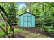 Turquoise storage shed surrounded by trees at 11469 Woodview Ct, Fishers, IN 46038