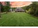 Expansive backyard view of a two story home featuring a large lawn, multiple decks, and ample outdoor living spaces at 11911 W Grandview Dr, Columbus, IN 47201
