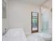 Bright bathroom with a soaking tub, walk in shower, and a door to the deck, creating a spa-like retreat at 11911 W Grandview Dr, Columbus, IN 47201