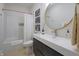 Well-lit bathroom with a modern vanity, round mirror, and combination tub/shower at 11911 W Grandview Dr, Columbus, IN 47201