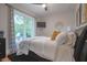 Cozy bedroom with a plush bed, ceiling fan, and bright window view at 11911 W Grandview Dr, Columbus, IN 47201