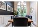 Bright dining area featuring a natural wood table, modern chandelier and a large arched window at 11911 W Grandview Dr, Columbus, IN 47201