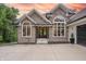 Stone-accented home featuring large arched windows and a three-car garage under a beautiful sunset at 11911 W Grandview Dr, Columbus, IN 47201