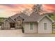 Charming home with a stone facade and a three-car garage set against a vibrant sunset backdrop at 11911 W Grandview Dr, Columbus, IN 47201