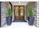 Stunning double front doors framed by stone accents and potted greenery, creating a welcoming entrance at 11911 W Grandview Dr, Columbus, IN 47201