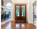 Elegant foyer featuring hardwood floors, a decorative front door, and views into the dining and living areas at 11911 W Grandview Dr, Columbus, IN 47201