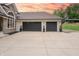 Three-car garage featuring sleek black doors and manicured landscaping, providing ample space and style at 11911 W Grandview Dr, Columbus, IN 47201
