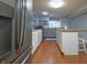 Open kitchen with stainless steel refrigerator, island seating, wood counters, and tiled floors at 11911 W Grandview Dr, Columbus, IN 47201