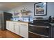 A well-stocked kitchenette includes white cabinets, wood countertop, and floating shelves with an oven and a fridge at 11911 W Grandview Dr, Columbus, IN 47201