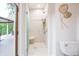 Accessible bathroom featuring a roll-in shower with grab bars, toilet, and sliding door to deck for convenience at 11911 W Grandview Dr, Columbus, IN 47201