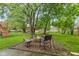 Landscaped backyard with mature trees, a fire pit, and a play area at 12524 Trophy Dr, Fishers, IN 46038