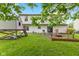 Large backyard featuring a well-maintained lawn, playhouse, and fire pit surrounded by mature trees at 12524 Trophy Dr, Fishers, IN 46038