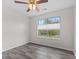 Minimalist bedroom featuring a ceiling fan, large window, and plank flooring at 12524 Trophy Dr, Fishers, IN 46038