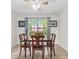 Cozy dining area with wood table, chairs, light fixture and large window with backyard view at 12524 Trophy Dr, Fishers, IN 46038
