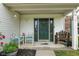 Covered front porch featuring a dark green front door, seating, and lush potted plants at 12524 Trophy Dr, Fishers, IN 46038