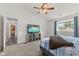 Carpeted main bedroom with ceiling fan, large windows, and access to an en-suite bathroom at 12524 Trophy Dr, Fishers, IN 46038