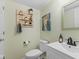 Stylish half bathroom with modern vanity, decorative mirror, and unique wall decor at 12524 Trophy Dr, Fishers, IN 46038