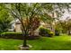 Lush backyard with manicured lawn, mature trees, and landscaped garden beds creating a private oasis at 12539 Pebblepointe Pass, Carmel, IN 46033