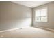 Spacious bedroom with neutral carpet and light gray walls with a window providing natural light at 12539 Pebblepointe Pass, Carmel, IN 46033