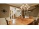 Dining room featuring hardwood floors and an elegant chandelier, adjacent to open staircase at 12539 Pebblepointe Pass, Carmel, IN 46033