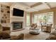 Bright living room with a brick fireplace, custom built-ins, large windows, and comfortable seating for relaxation and entertainment at 12539 Pebblepointe Pass, Carmel, IN 46033