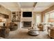Cozy living room boasts a fireplace, custom built-ins, recessed lighting, and comfortable seating for relaxed living at 12539 Pebblepointe Pass, Carmel, IN 46033