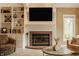 Living room features a brick fireplace, custom built-ins, large windows, and comfortable seating for relaxing and entertaining at 12539 Pebblepointe Pass, Carmel, IN 46033