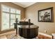 Cozy living room with grand piano, artwork and a large window letting in plenty of natural light at 12539 Pebblepointe Pass, Carmel, IN 46033