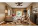 Inviting living room with hardwood floors, ceiling fan, stylish furnishings, and a beautiful garden view through the windows at 12539 Pebblepointe Pass, Carmel, IN 46033
