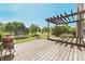 Backyard featuring a wood deck with pergola, trampoline, grill, and fire pit in the lawn at 12677 Honors Dr, Carmel, IN 46033