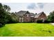 Stately brick home features an expansive green lawn, mature trees, and an inviting front entrance at 12854 Northants Cir, Carmel, IN 46032
