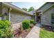 Close-up view of a charming brick home's entrance with lush landscaping and blooming flowers at 13911 Naples Dr, Fishers, IN 46038