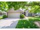 Charming brick home with a well-manicured lawn, mature trees, and an attached two-car garage at 13911 Naples Dr, Fishers, IN 46038