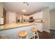 Well-lit kitchen with white cabinets, granite countertops, and barstool seating at the island at 13911 Naples Dr, Fishers, IN 46038