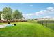 Expansive backyard featuring a lush lawn, black metal fencing, and views of surrounding homes at 14036 Rayners Ln, Fishers, IN 46037