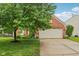 Charming brick home featuring an attached garage, well-maintained lawn, and mature trees at 14036 Rayners Ln, Fishers, IN 46037