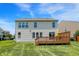 Back of the house with large windows, a wooden deck with seating, and a well-maintained lawn at 14499 Milton Rd, Fishers, IN 46037