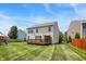 A view of the back exterior highlighting a wooden deck, spacious lawn, and the house's design at 14499 Milton Rd, Fishers, IN 46037