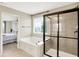 Modern bathroom featuring a shower, tub, and window with view to the landscaped outdoors at 14499 Milton Rd, Fishers, IN 46037