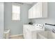 Laundry room featuring a washer, dryer, utility sink, and storage cabinets at 14499 Milton Rd, Fishers, IN 46037